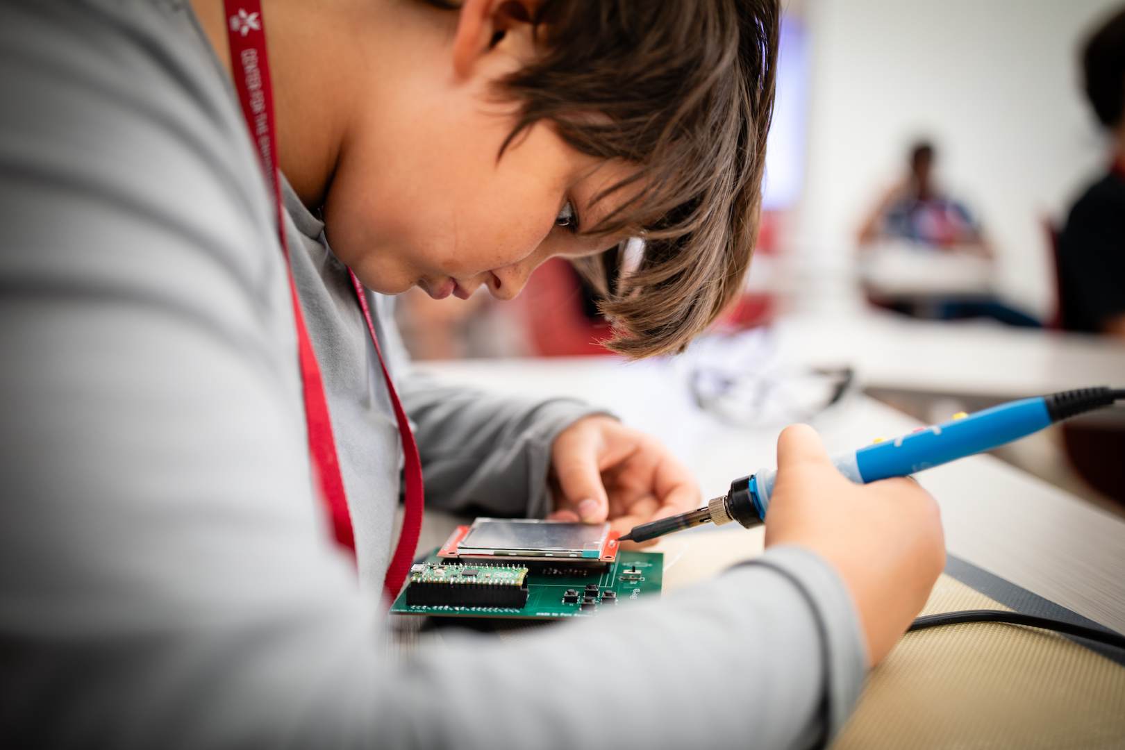 A students using a soldering iron.