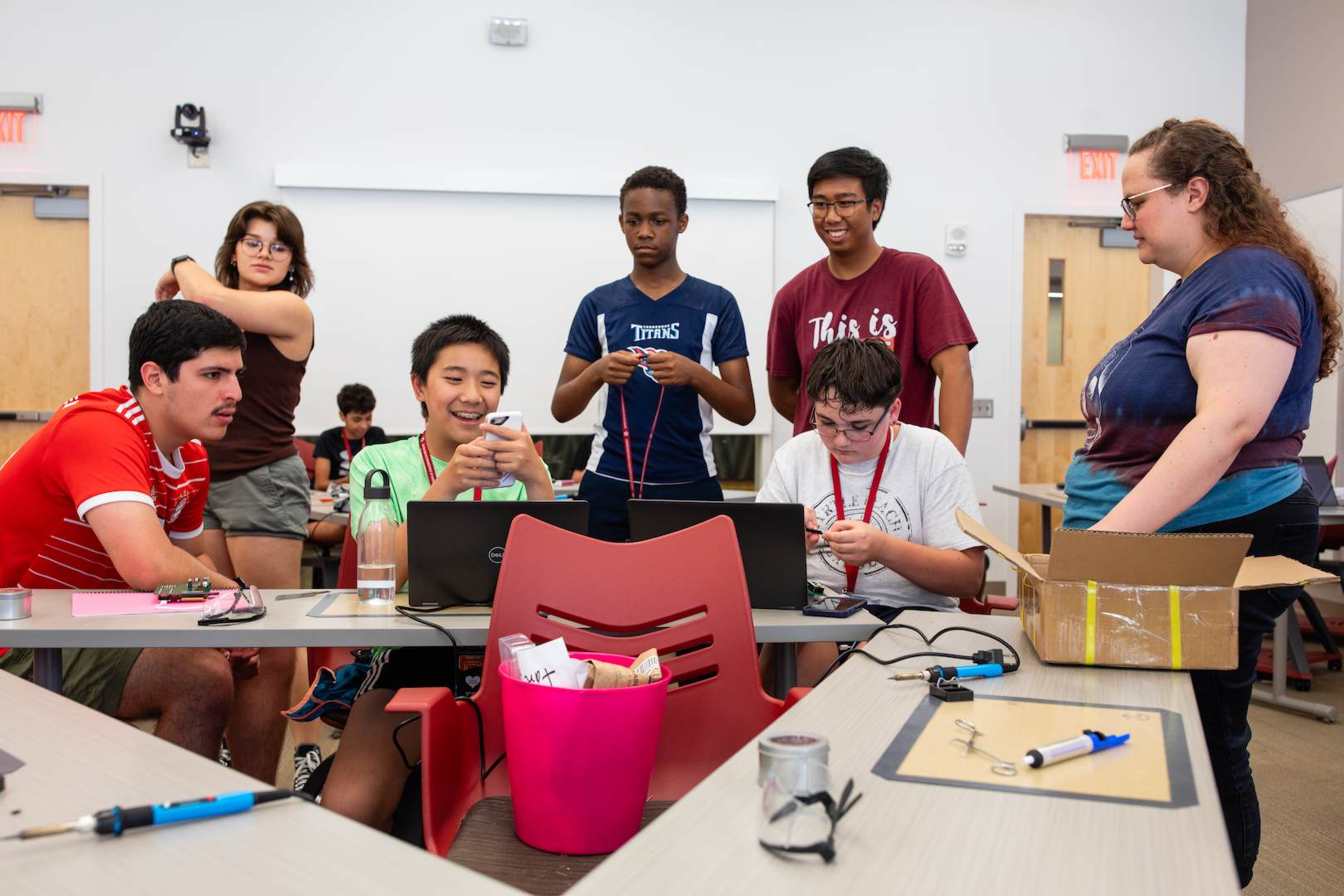 A group of students talking about info on a mobile phone