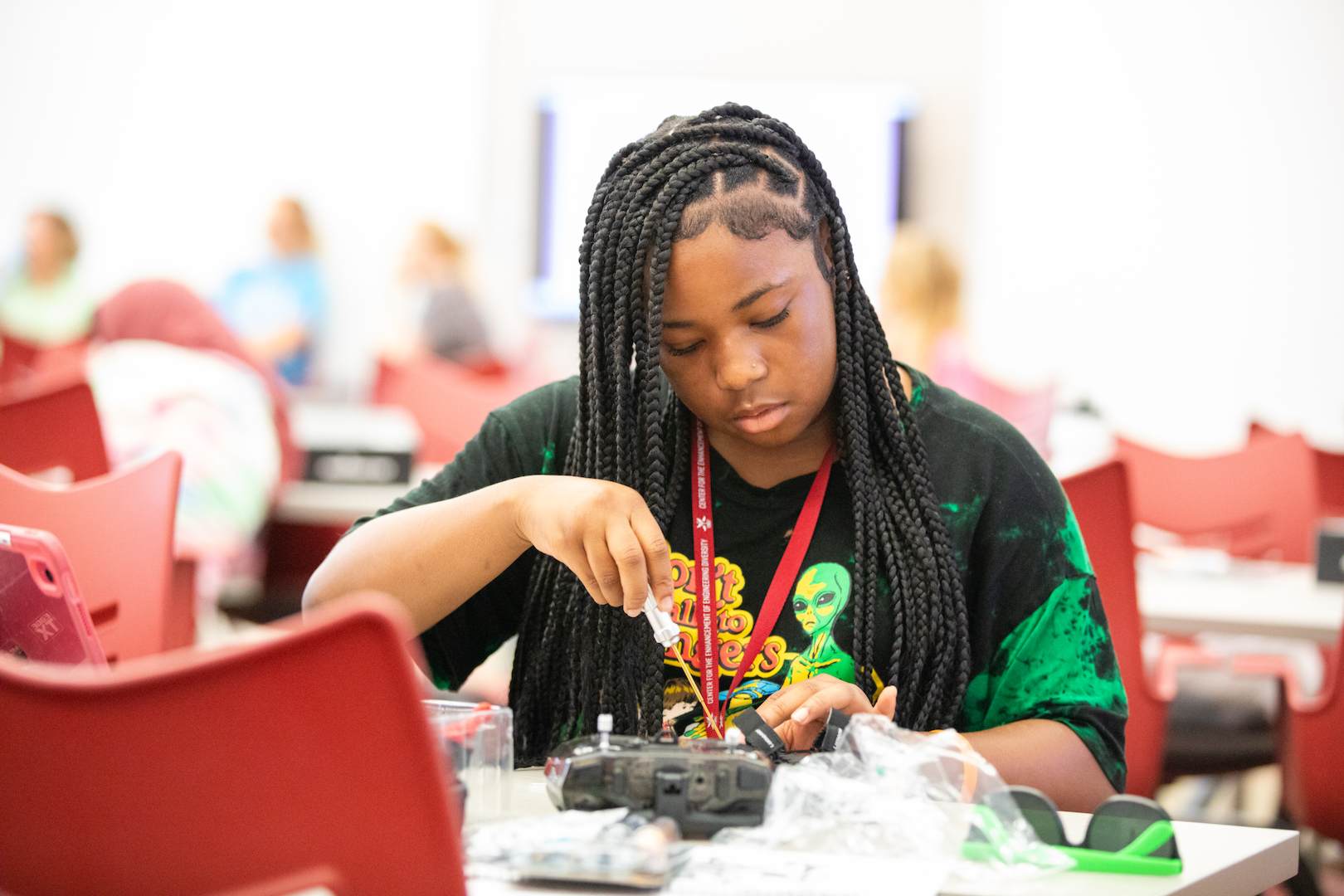 Student using a screwdriver on her drone
