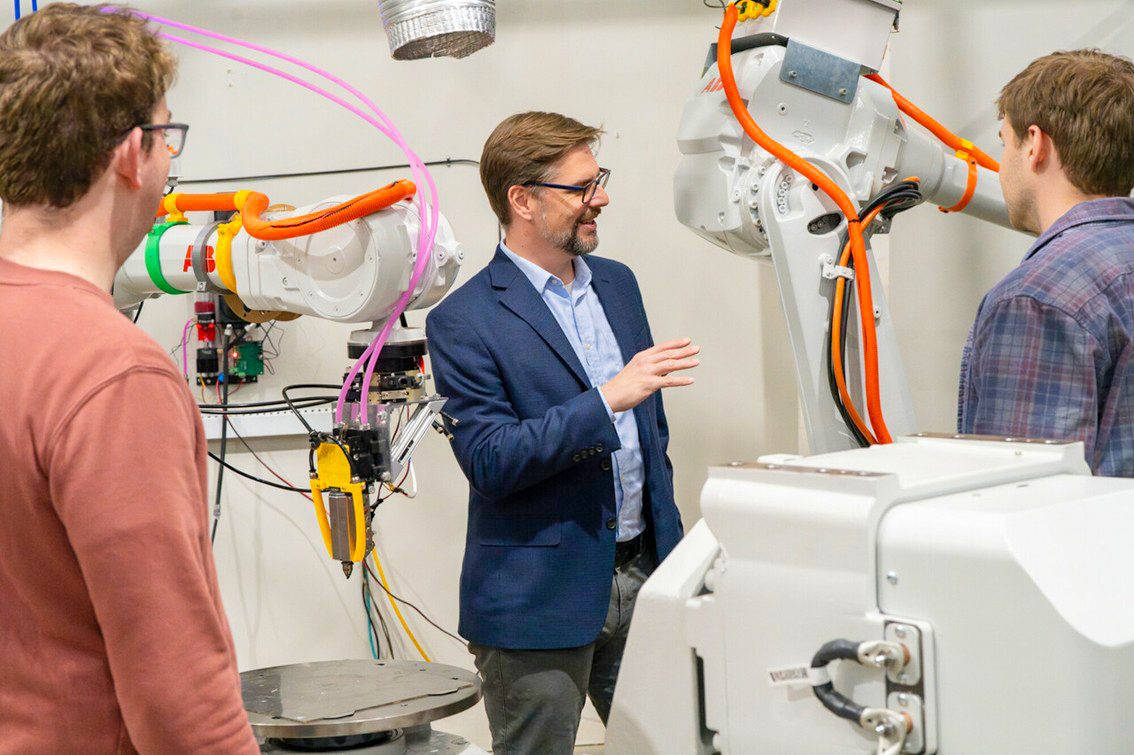 Chris Williams standing near robots